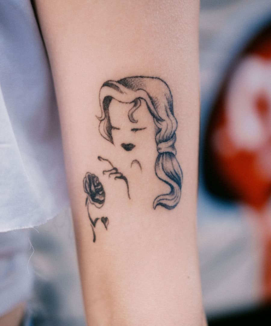 Healed fine line portrait of a woman beside a single rose on a forearm