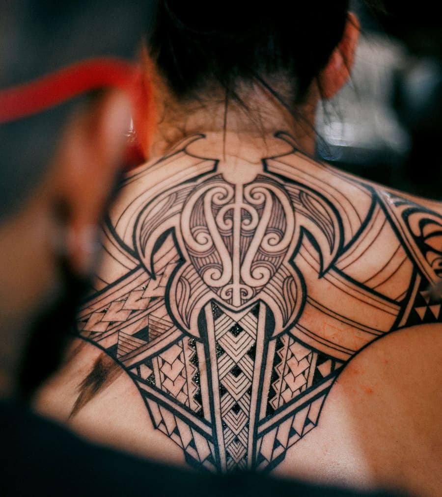 Healed ornamental blackwork yoke across the upper back and shoulders