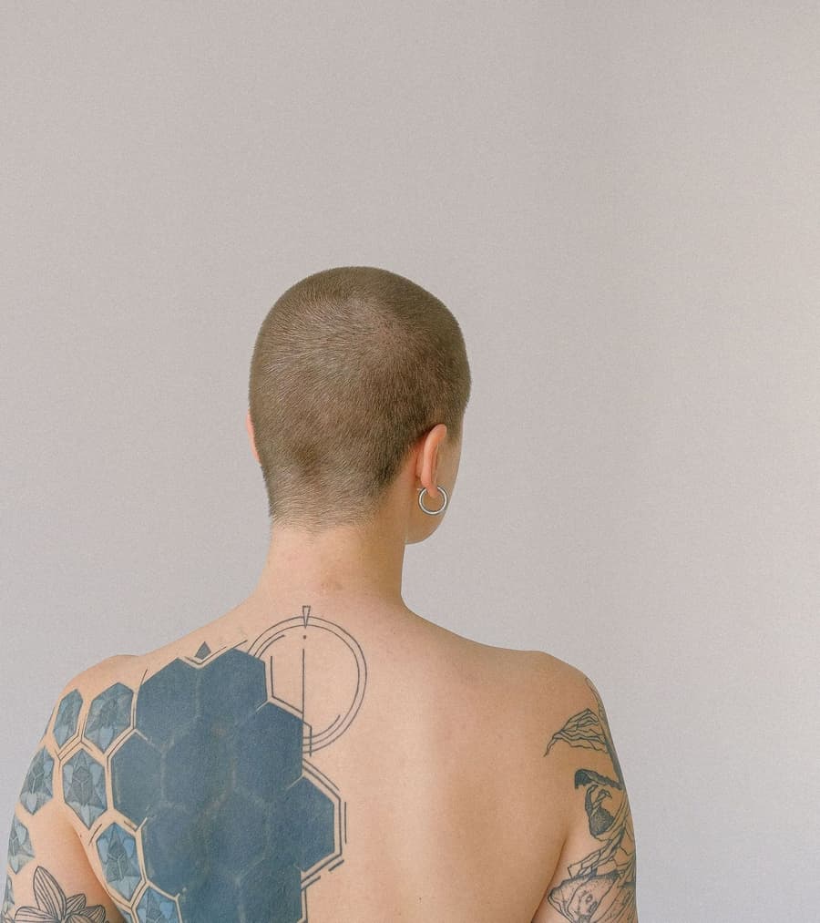 Healed solid black hexagon cover-up across a shoulder blade