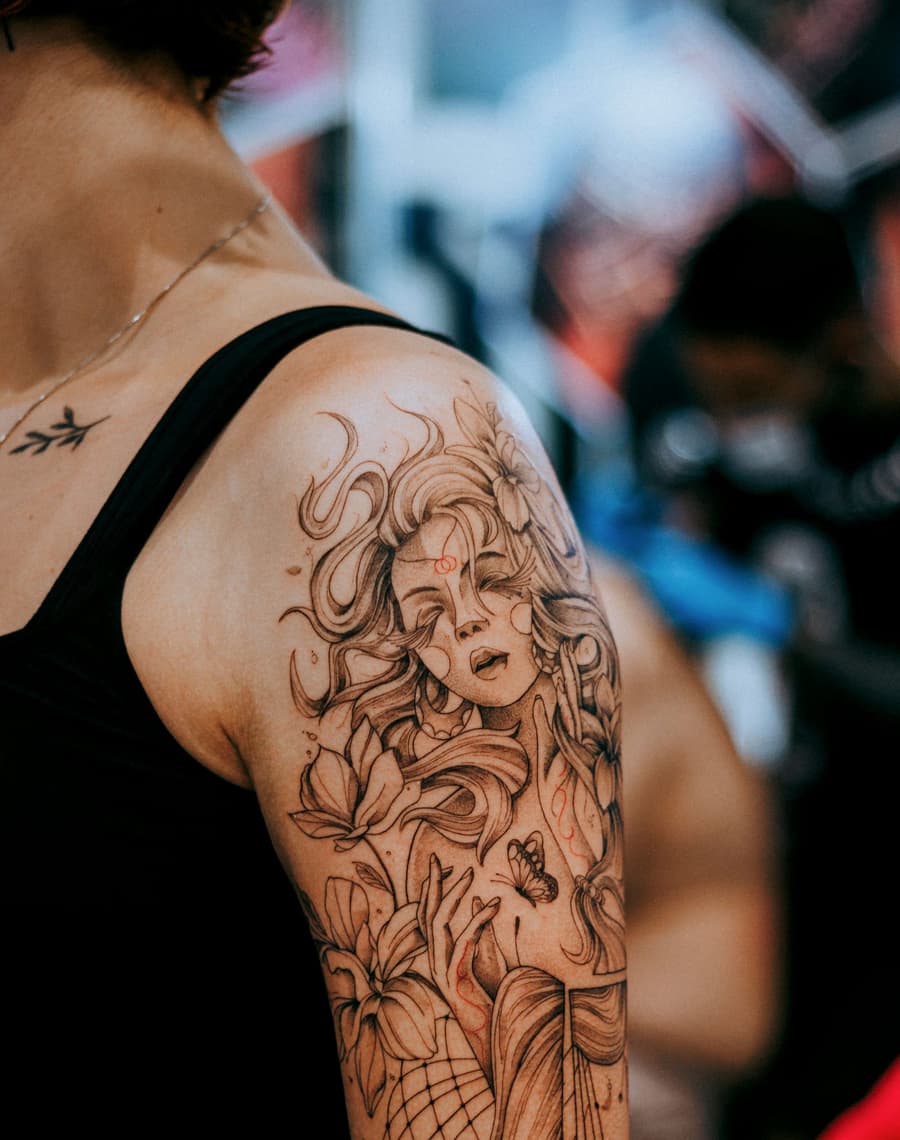 Healed portrait of a woman with flowing hair and lilies on an upper arm