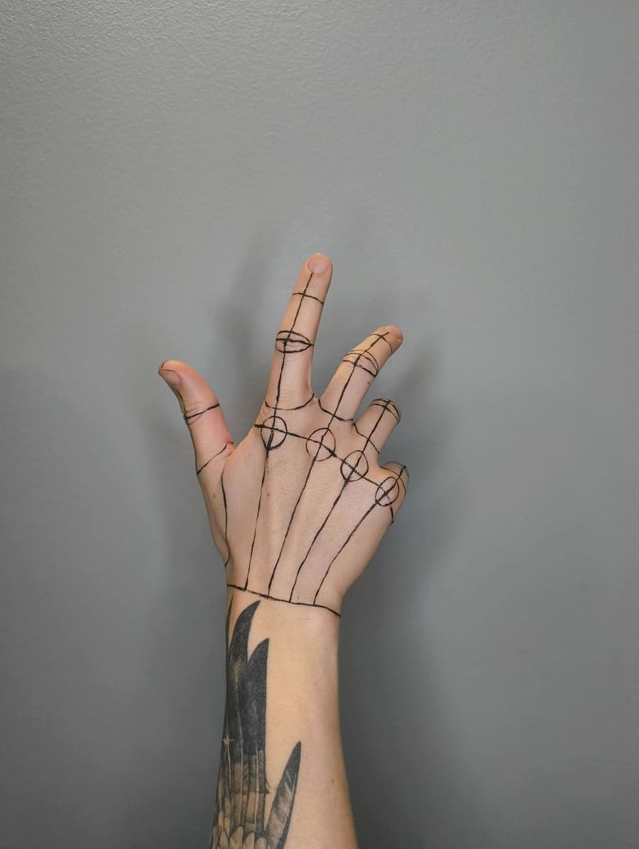 Healed fine line drawing of the bones of the hand along the fingers and wrist