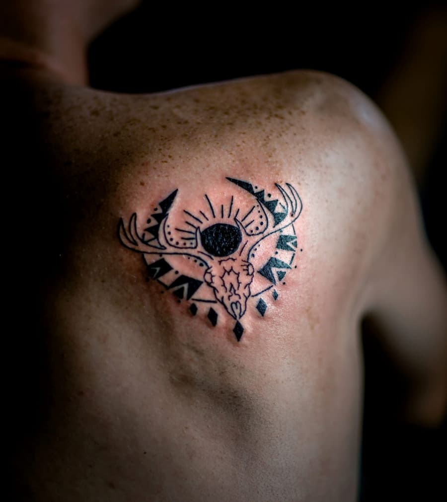 Fresh black stag skull with dotwork on a shoulder blade