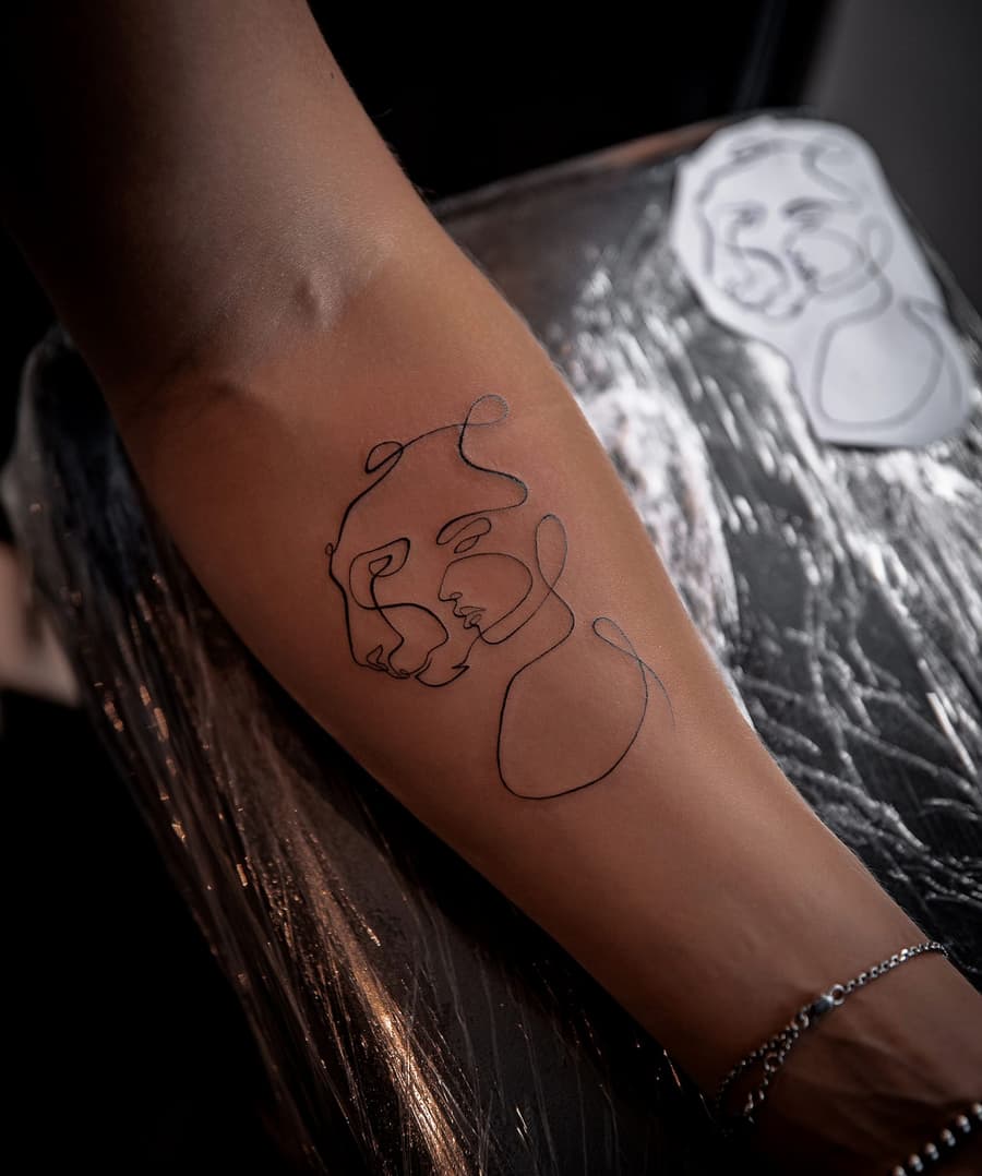 Fresh single line drawing of two faces on a forearm