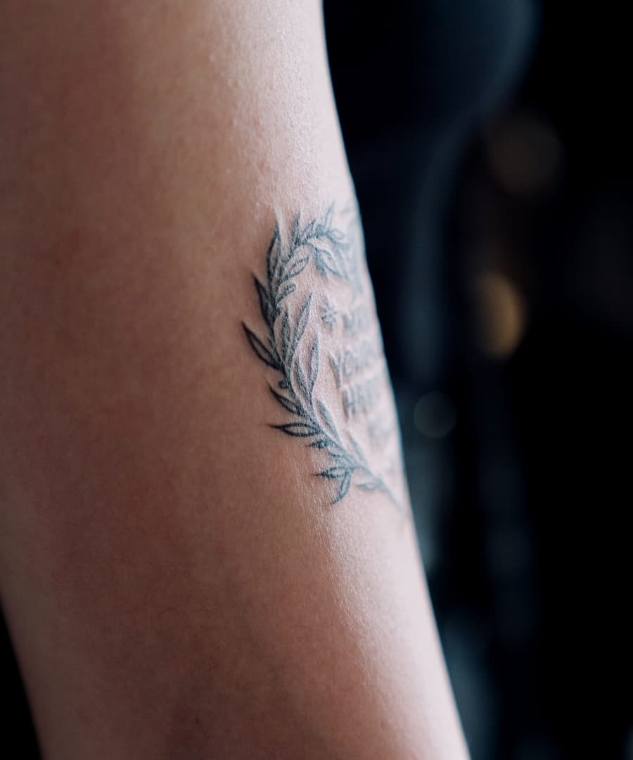 Healed fine line olive branch on an inner arm