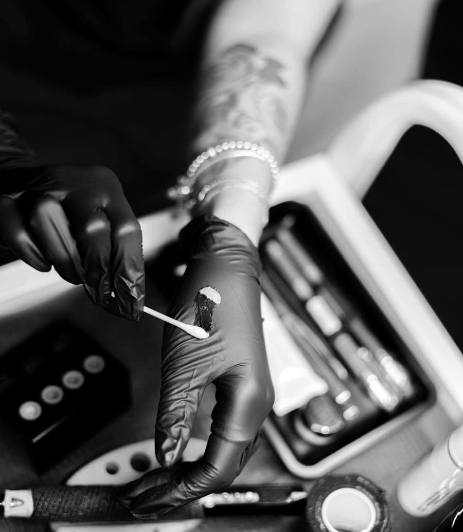 Tess's gloved hands setting out ink caps beside the machine