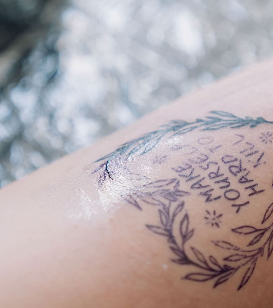 A fresh fine line tattoo just after the session, the skin still shining