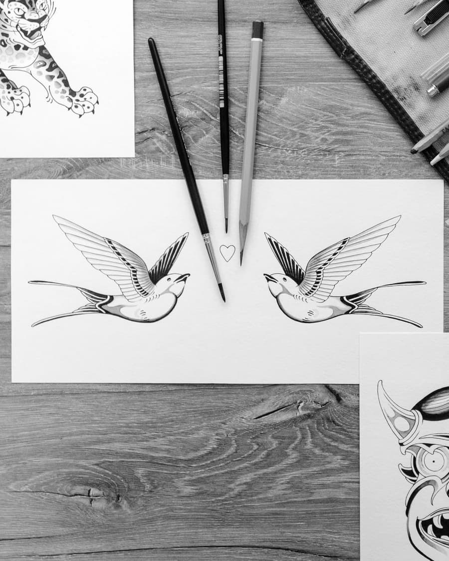 Flash drawing of two swallows facing a small heart, brushes beside the sheet